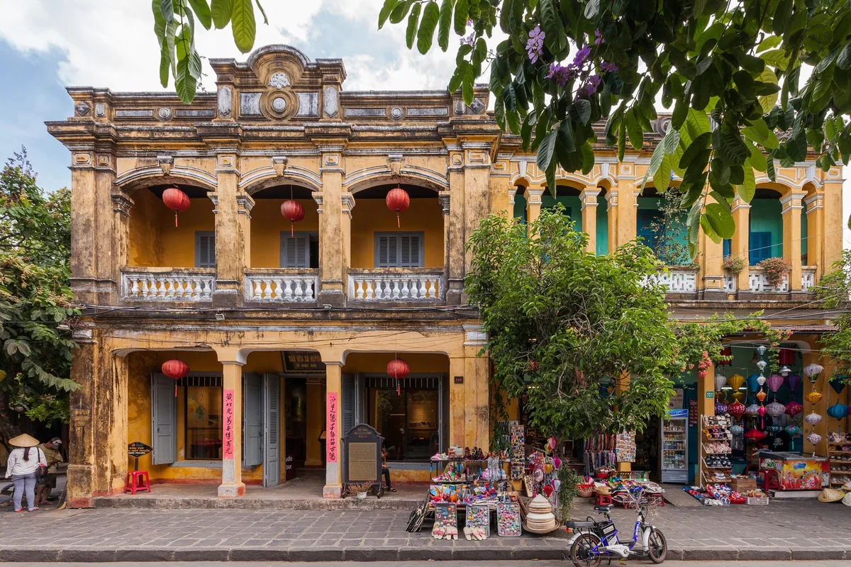 Dãy nhà cổ mái ngói tường vàng bên bờ sông ở phố cổ Hội An, đèn lồng treo trước hiên