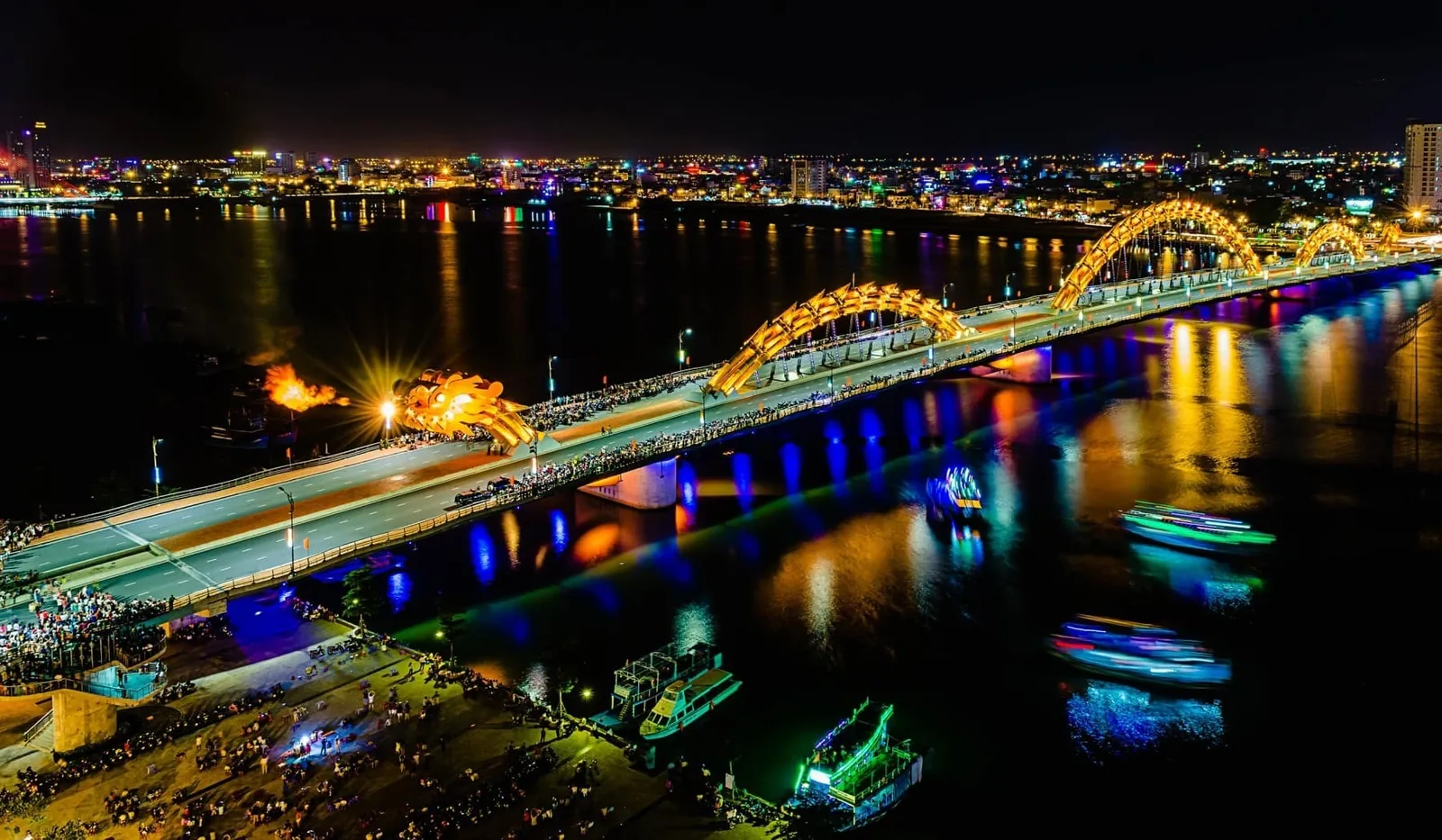 Cầu Rồng phun lửa trên sông Hàn về đêm, đèn cầu đổi màu phản chiếu mặt nước